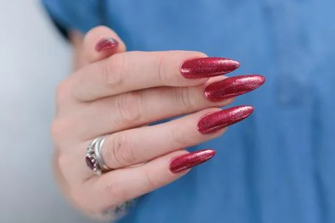 Hand with long nails and a bright red manicure Foto stock
