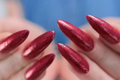 Hand with long nails and a bright red manicure Photos