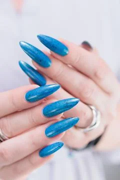 Hand with long nails and bright blue manicure Photos