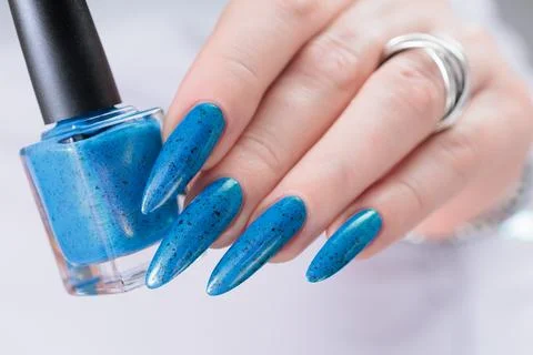 Hand with long nails and bright blue manicure 写真素材