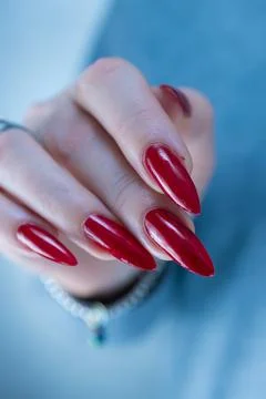Hand with long nails and a bright red manicure Stock Photos