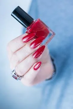 Hand with long nails and a bright red manicure 库存照片