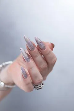 Hand with long nails and a gray silver and red manicure Stock Photos