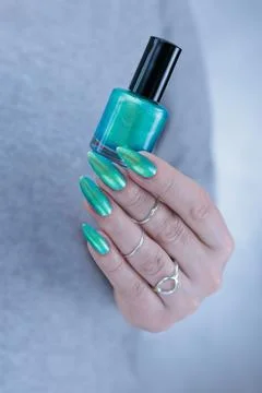 Hand with long nails and light green and blue turquoise manicure Photos