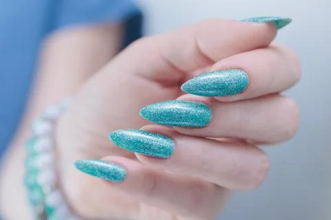 Hand with long nails and light green and blue turquoise manicure Stock Photos