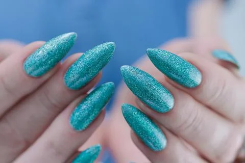 Hand with long nails and light turquoise manicure, blue and green color Photos