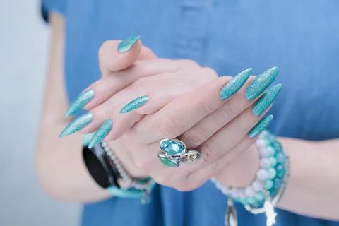 Hand with long nails and light turquoise manicure, blue and green color 스톡 사진