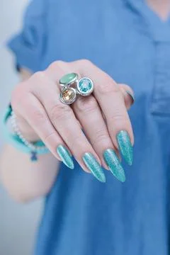 Hand with long nails and light turquoise manicure, blue and green color Photos