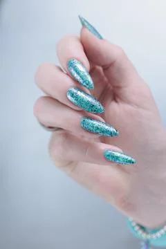 Hand with long nails and light turquoise manicure, blue and green color Stock-Fotos