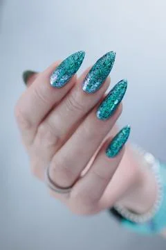 Hand with long nails and light turquoise manicure, blue and green color Stock Photos