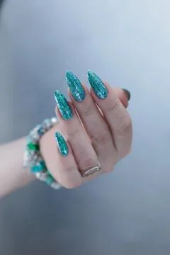 Hand with long nails and light turquoise manicure, blue and green color 스톡 사진