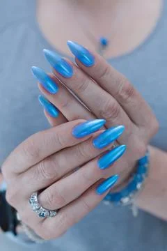 Hand with long nails and light baby blue manicure Stockfoto's