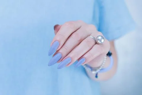 Hand with long nails and light baby blue manicure Stock Photos