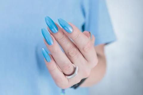 Hand with long nails and light baby blue manicure Stock Photos