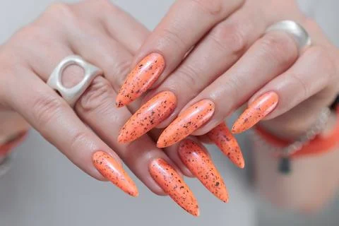 Hand with long nails and light orange neon manicure Stock Photos