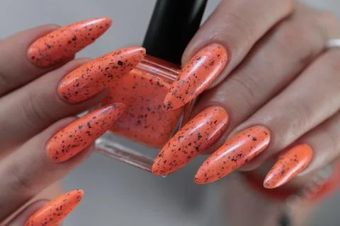 Hand with long nails and light orange neon manicure 스톡 사진