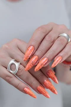 Hand with long nails and light orange coral neon manicure Фото