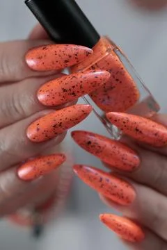 Hand with long nails and light orange neon manicure Stock Photos