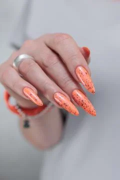 Hand with long nails and light orange neon manicure 스톡 사진