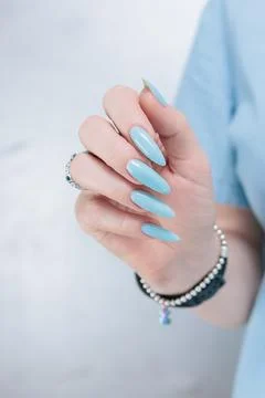 Hand with long nails and light baby blue manicure 스톡 사진