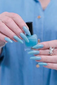 Hand with long nails and light baby blue manicure 스톡 사진
