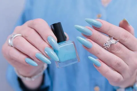 Hand with long nails and light baby blue manicure 스톡 사진