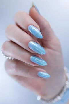 Hand with long nails and light baby blue manicure Foto stock