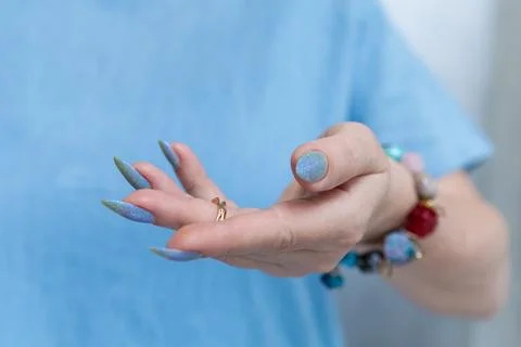 Hand with long nails and light baby blue manicure Stock Photos