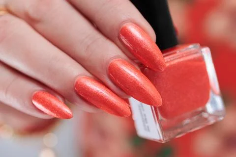 Hand with long nails and light orange neon manicure 写真素材
