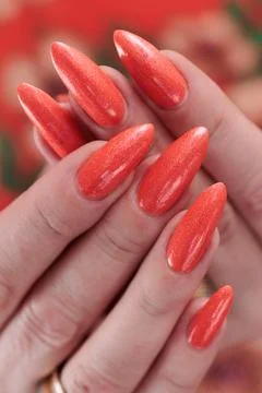 Hand with long nails and light orange neon manicure Stock Photos