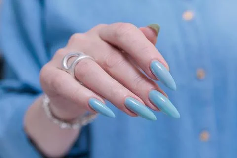 Hand with long nails and light baby blue manicure Stockfoto's