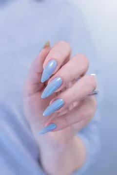 Hand with long nails and light baby blue manicure Stock Photos