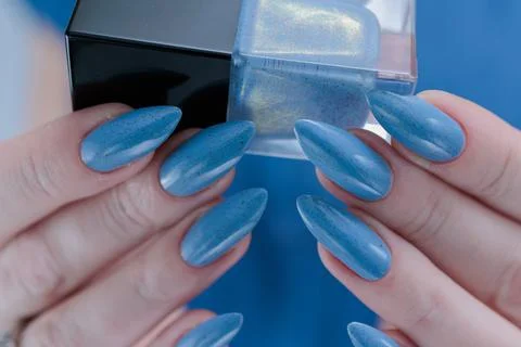 Hand with long nails and light baby blue manicure Stockfoto's