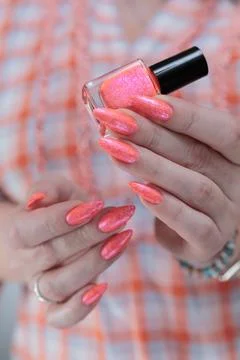 Hand with long nails and light orange coral pink manicure Stock Photos