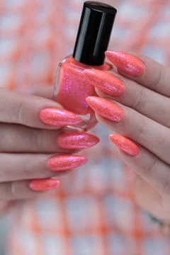 Hand with long nails and light orange coral pink manicure Stock Photos
