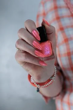 Hand with long nails and light orange coral pink manicure Stock Photos