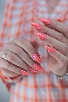 Hand with long nails and light orange coral pink manicure Stock Photos