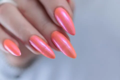 Hand with long nails and light orange coral pink manicure 스톡 사진