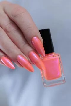 Hand with long nails and light orange coral pink manicure Stock Photos