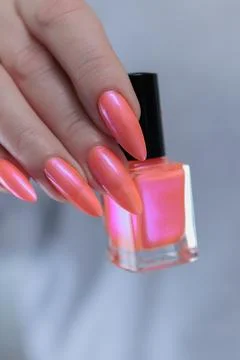Hand with long nails and light orange coral pink manicure Stock Photos
