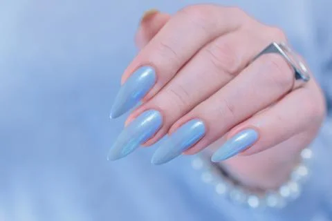 Hand with long nails and light baby blue manicure Photos