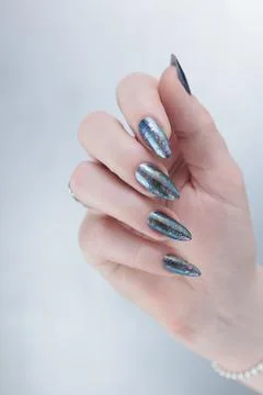 Hand with long nails gray metallic manicure Stockfoto's