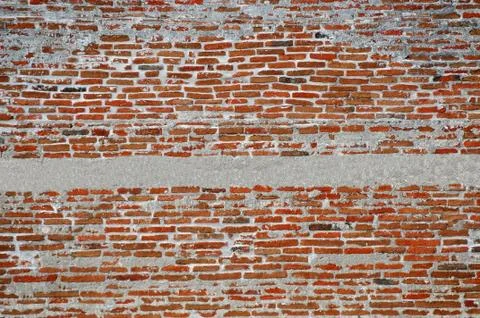 Hand made brick wall made from narrow long bricks with a strip of cement plas Foto stock