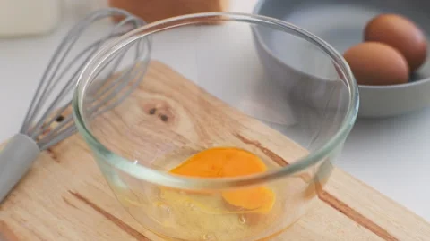 Hand made cracked fresh egg yolks dripping into the bowl.  Stock Footage 242565368