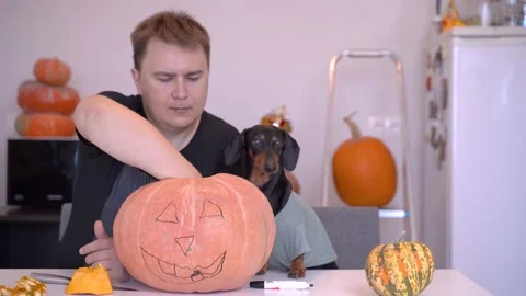 Hand made process of creating Jack O Lantern. Young handsome man with his cut Stock Footage 133531110