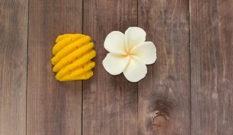 Hand made soap in the shape of fruit yellow pineapple and flower on wooden Stock Photos
