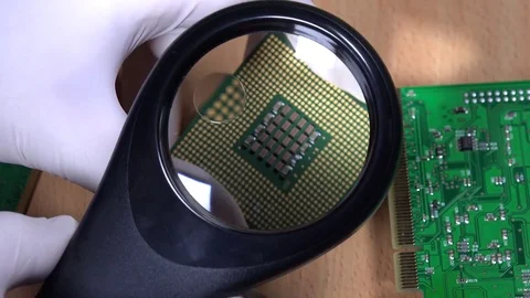 Hand with magnifying glass examining computer cpu processor Stock Footage 72972454