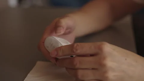 Hand maintaining electric nail clipper, carefully detaching cover and tapping Stock Footage 323345665
