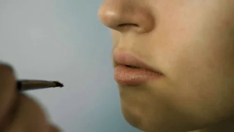 Hand of make-up master, painting lips of young beautiful model. Makeup in 스톡 동영상 82061963