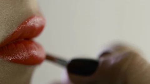 Hand of make-up master, painting lips of young beautiful model. Makeup in 스톡 동영상 82084300